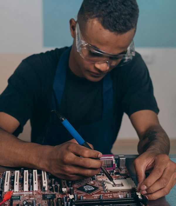 Man engineer with focused expression examining electronic components carefully